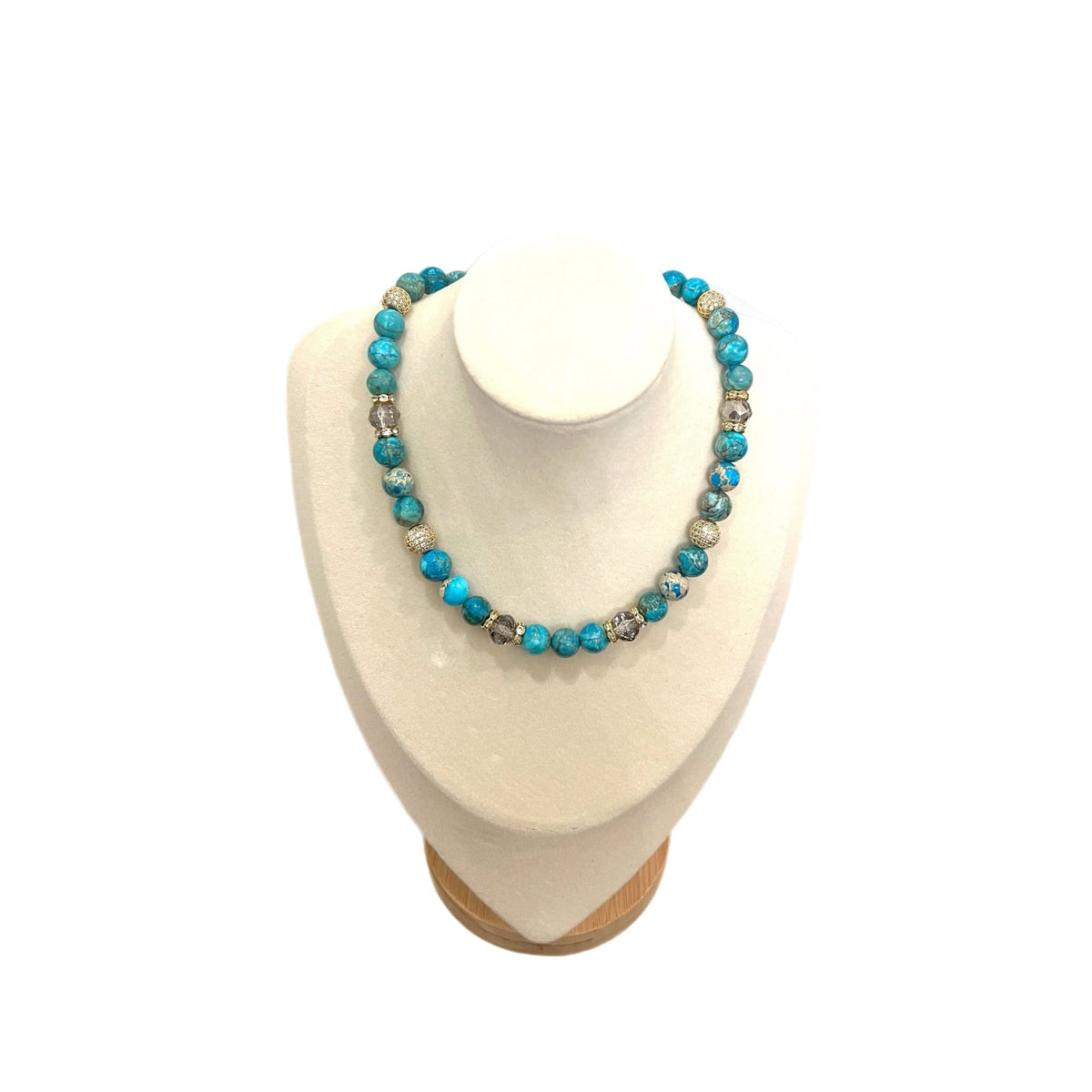 The Andrea Necklace — turquoise with Austrian crystals and gold beads, on a white display bust