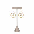 Citrine Quartz Teardrop & Clear Crystal Earrings on a grey earring stand: a faceted citrine drop below two clear crystals inside hammered gold teardrop hoops