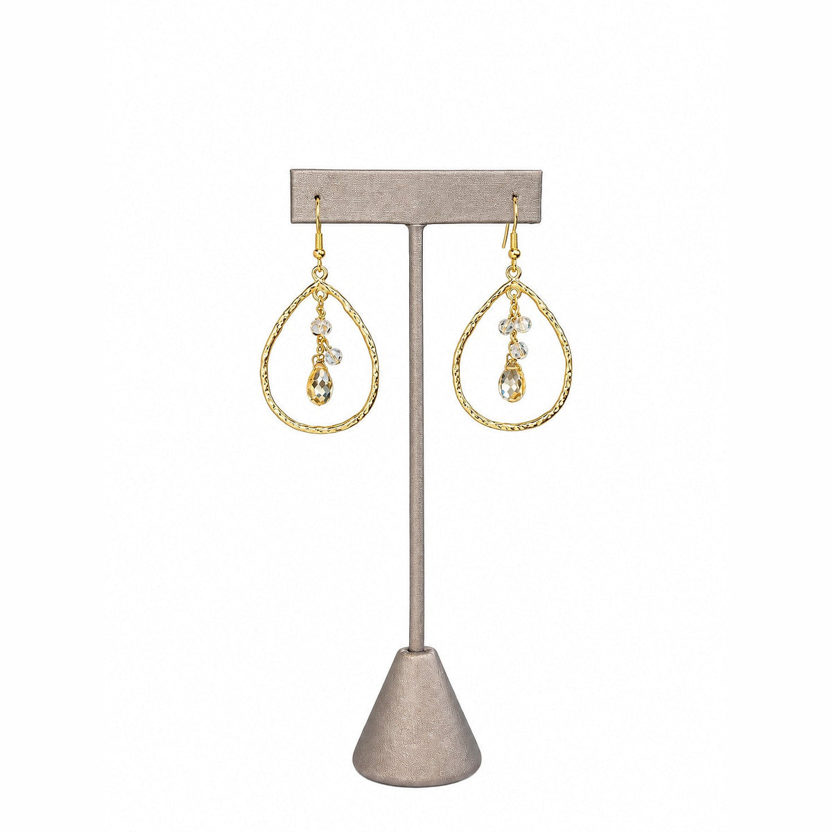 Citrine Quartz Teardrop & Clear Crystal Earrings on a grey earring stand: a faceted citrine drop below two clear crystals inside hammered gold teardrop hoops