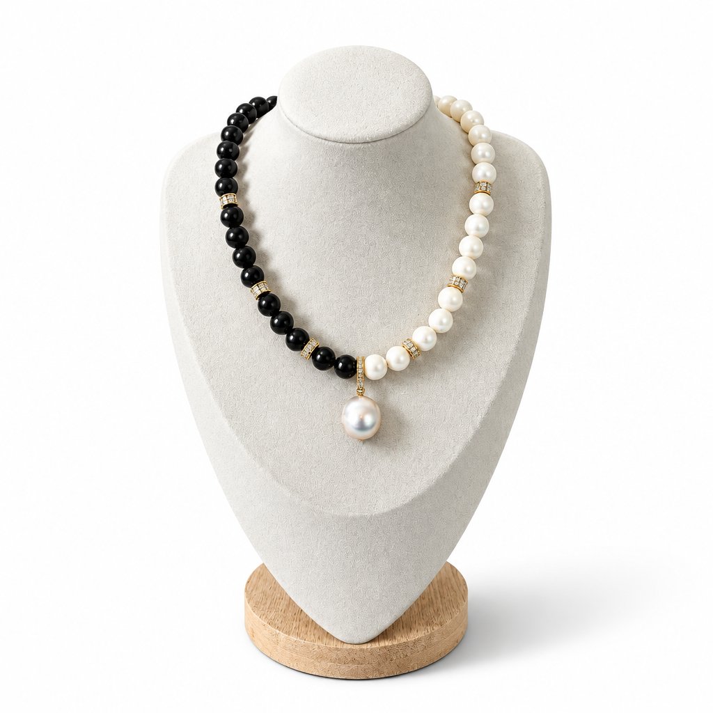 The Helena Necklace on a display bust: black onyx on one side, white pearls on the other, with a baroque pearl drop
