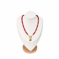 The Julia Necklace on a display bust: faceted ruby-red beads with a gold ring clasp, heart and star charms