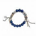 Lapis lazuli stretch bracelet with silver-grey glass pearls, smoky Austrian crystals and gold pavé rondelles, a crystal heart charm and silver and gold chain tassels