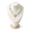 Moonstone, shell and cultured pearl necklace on a display bust: pale cream and blush pearls with gold pavé accents and a gold pavé heart pendant