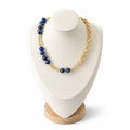 Sodalite necklace on a display bust: deep blue beads in groups set between gold tubes on one side, a gold link chain on the other
