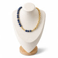 Sodalite necklace on a display bust: a long run of deep blue beads on one side, a gold link chain on the other